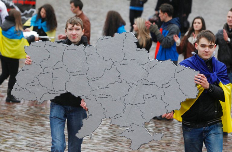 A protester holds up a map of Ukraine, showcasing its 1991 borders.