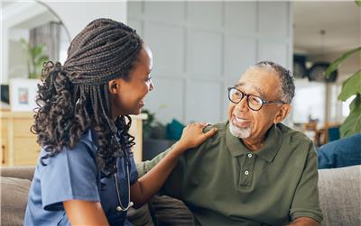 A health care worker discusses with an elderly patient.