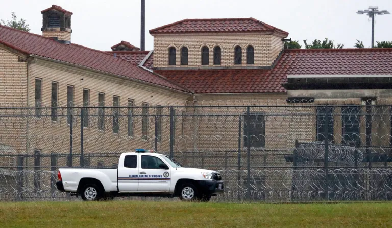 A Federal Bureau of Federal Prisons truck drives past barbed wire fences at the Federal Medical Center prison in Fort Worth, Texas.