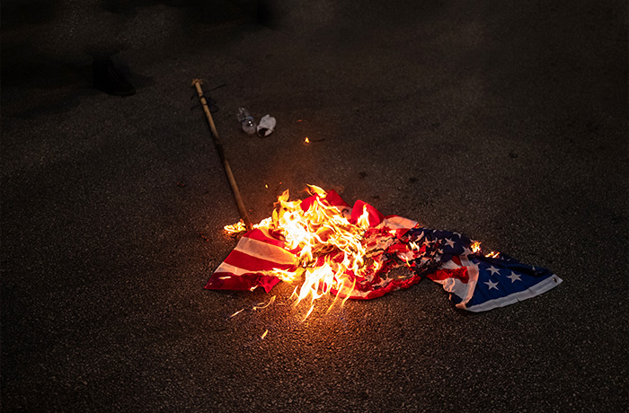 Protesters burn a U.S. flag outside the Democratic National Convention in Chicago, August 22, 2024. (Jim Vondruska/Getty Images)