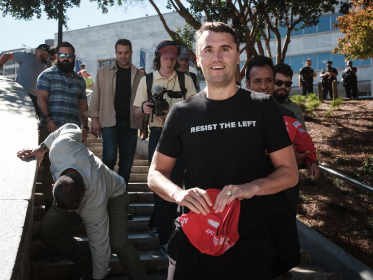 US conservative political activist and YouTuber Charlie Kirk (R) holds a red cap supporting former US President and Republican presidential candidate Donald Trump as he arrives to attend a rally at Hurt Park next to the campus of Georgia State University in Atlanta, Georgia, on October 21, 2024. (Photo by Yasuyoshi CHIBA / AFP) (Photo by YASUYOSHI CHIBA/AFP via Getty Images)