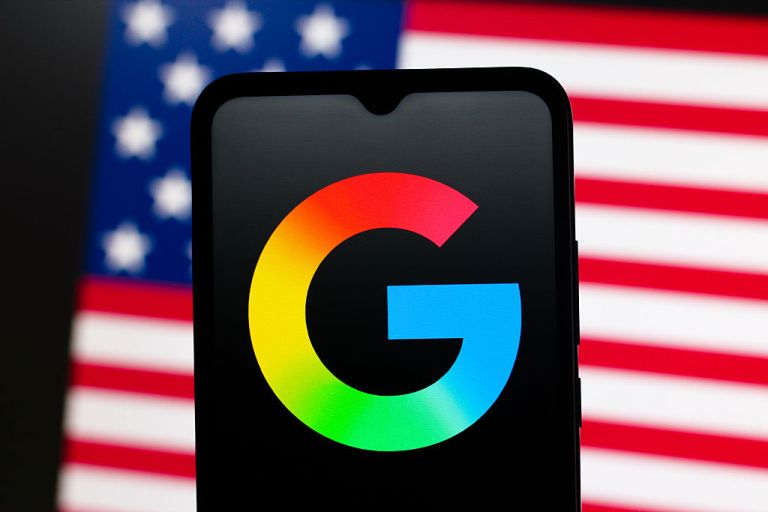 Google logo is seen displayed on a smartphone screen and the United States flag in the background. (Photo Illustration by Thomas Fuller/SOPA Images/LightRocket via Getty Images)