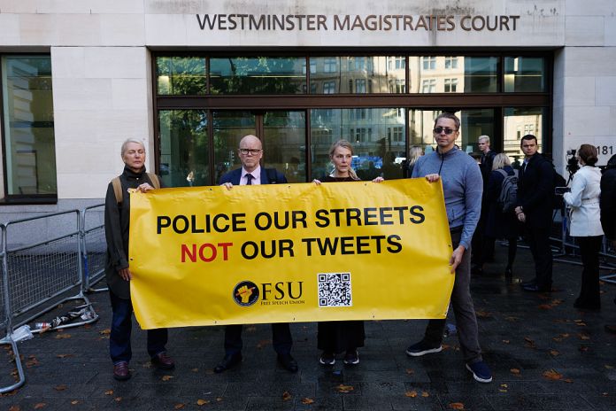 Members of the free speech Union hold a banner reading 'Police our Streets not Our Tweets' as Graham Linehan arrives at Westminster Magistrates Court on September 4, 2025 in London, England. Irish comedy writer Graham Linehan is appearing in court charged with harassment without violence and criminal damage in connection with an incident that took place last year. Linehan, who is known for co-creating TV sitcoms such as Father Ted and The IT Crowd, has also been outspoken against the trans-rights movement. Linehan was arrested on Monday on suspicion of inciting violence over anti-trans social media posts he made earlier this year. His latest arrest has sparked a backlash from free speech advocates. (Photo by Dan Kitwood/Getty Images)