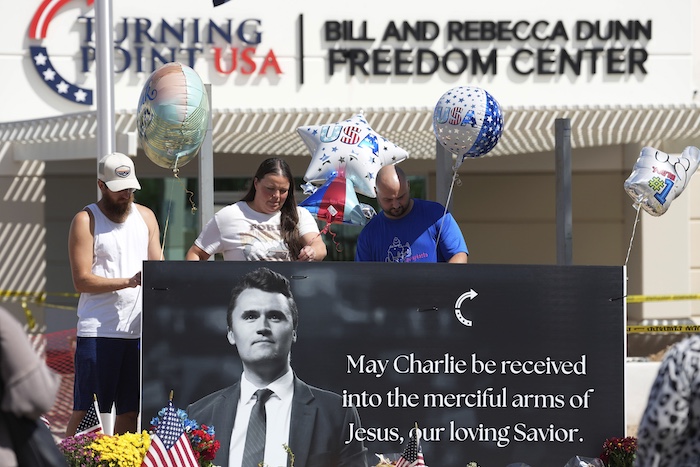 People add balloons to a makeshift memorial set up at Turning Point USA's headquarters.