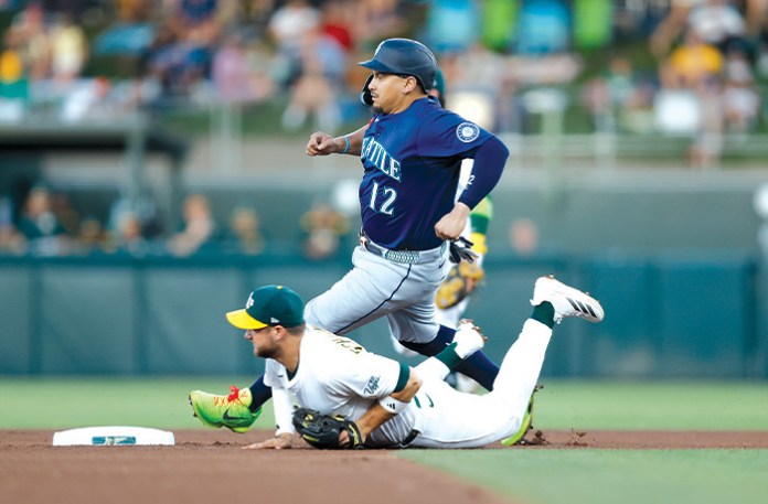 Josh Naylor of the Seattle Mariners steals second base as Max Schuemann of the Athletics is unable to field a throw in the top of the fourth inning on July 28 in Sacramento, California. (Lachlan Cunningham/Getty Images)