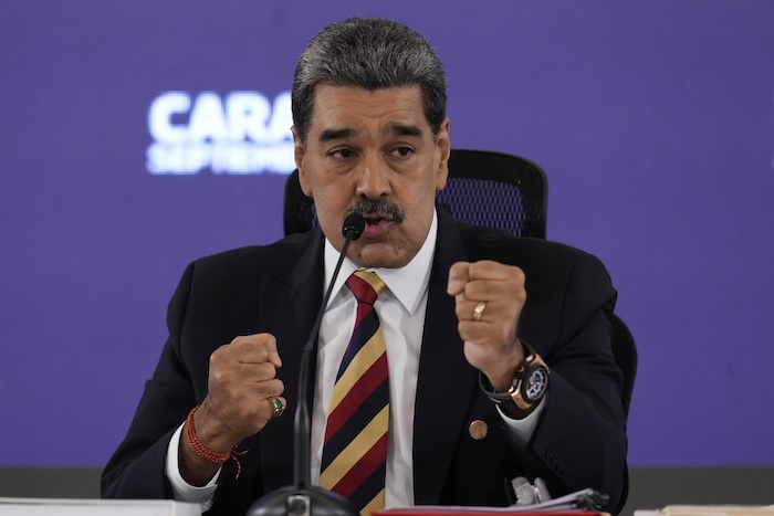 Venezuelan leader Nicolas Maduro raises his fists.