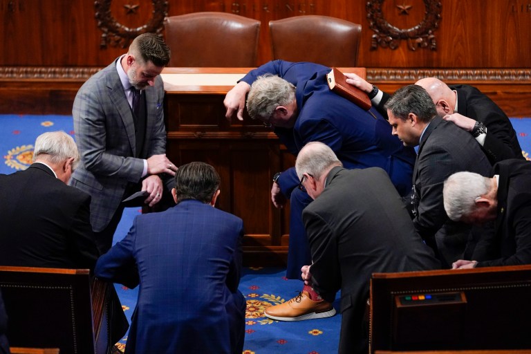 Members of Congress pray in the House chamber.