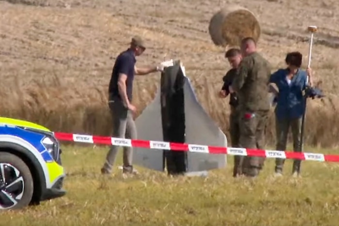 Police and military police secure parts of a damaged object shot down by Polish authorities at a site in Wohyn, Poland.