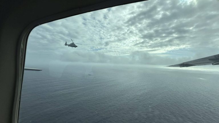 A Chinese military helicopter flies close to a Philippine Bureau of Fisheries and Aquatic aircraft above Scarborough shoal.