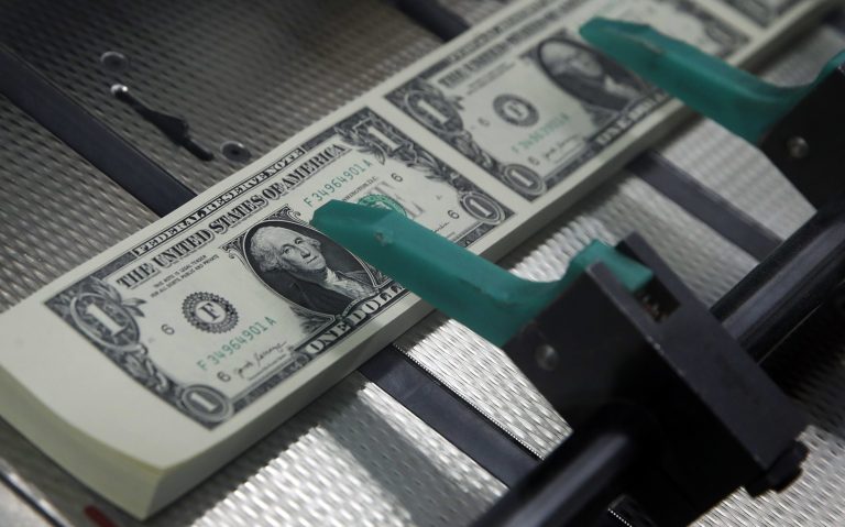 New $1 bills are cut and stacked.