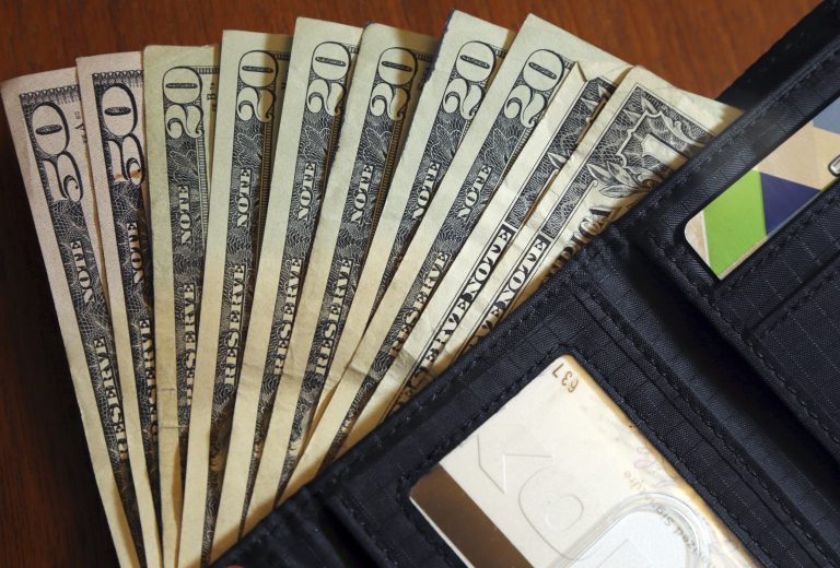 In this June 15, 2018, file photo, cash is fanned out from a wallet in North Andover, Mass. (AP Photo/Elise Amendola, File)