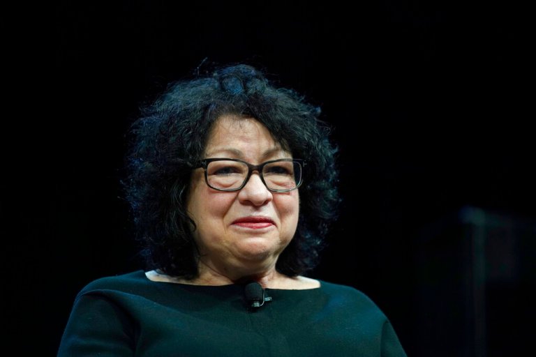 Supreme Court Justice Sonia Sotomayor smiles in front of an audience.