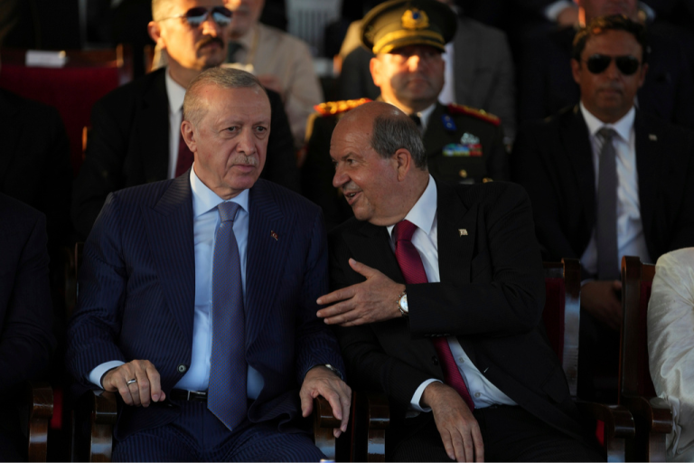 Turkish President Recep Tayyip Erdogan, left, and Turkish Cypriot leader Ersin Tatar talk to each other during a military parade marking the 51st anniversary of the 1974 Turkish invasion on Sunday, July 20, 2025, in the Turkish occupied area in the divided capital of Nicosia, Cyprus.