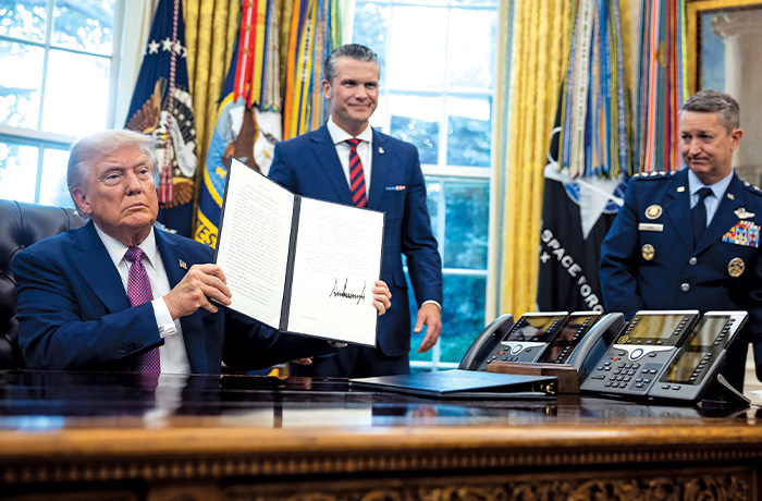 President Trump displays the signed executive order renaming the Department of Defense the Department of War at the White House.