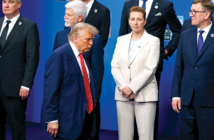 President Donald Trump walks by Denmark’s Prime Minister Mette Frederiksen, center front, at the NATO summit in the Netherlands on June 25. (Geert Vanden Wijngaert/AP)