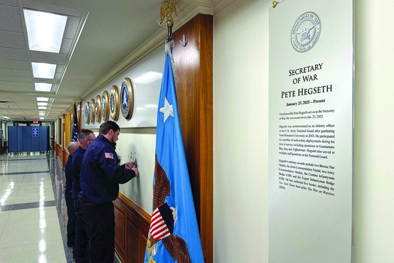 Workers remove sign lettering at the Pentagon after President Donald Trump signed an executive order aiming to rename the Department of Defense the Department of War in Washington, Friday, Sept. 5, 2025. (AP Photo/Mike Pesoli)