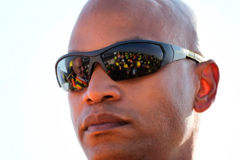Members of the press are reflected in safety glasses worn by Maryland Gov. Wes Moore during a press conference after a tour of the demolition work zone for the remaining portions of the Francis Scott Key Bridge, Wednesday, July 30, 2025, in Baltimore.
