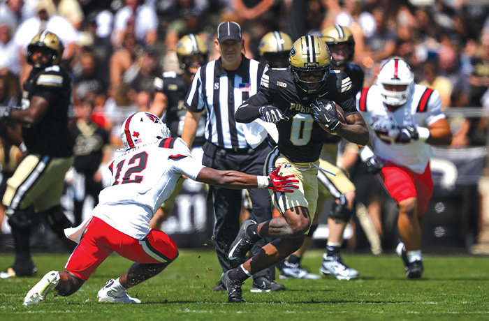 Purdue wide receiver Nitro Tuggle (0) runs past Ball State University defensive back Deondre Shepherd (12).