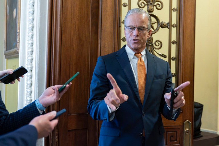 Sen. John Thune gestures in front of reporters.