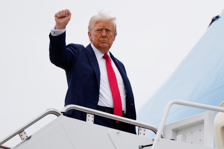 President Donald Trump raises his fist as he boards Air Force One.