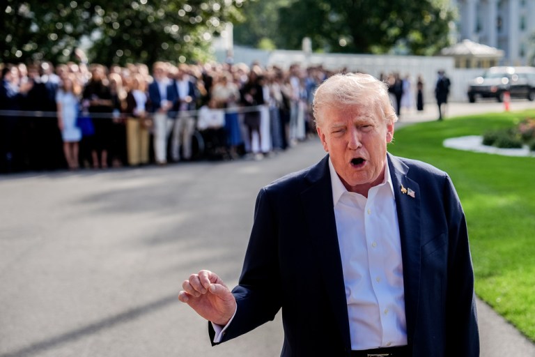 President Donald Trump speaks with a crowd peering over at him