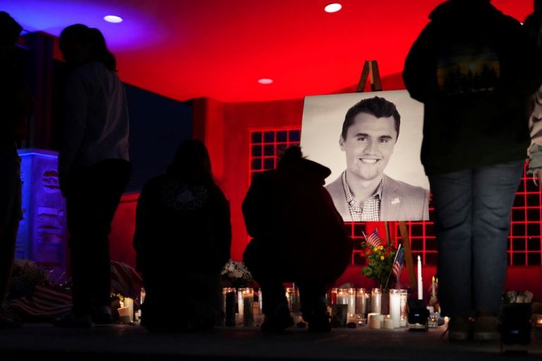 People place lit candles below a photo of Charlie Kirk, the CEO and co-founder of Turning Point USA who was shot and killed, at a vigil in his memory, Thursday, Sept. 11, 2025, in Orem, Utah. (AP Photo/Lindsey Wasson)