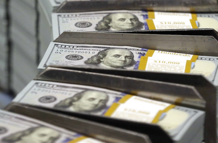 In this Sept. 24, 2013, file photo, freshly-cut stacks of $100 bills make their way down the line at the Bureau of Engraving and Printing Western Currency Facility in Fort Worth, Texas.