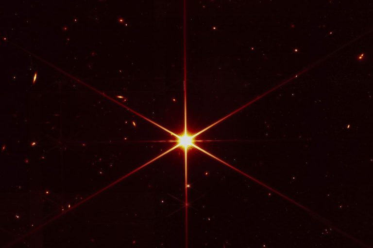 Star 2MASS J17554042+6551277 used to align the mirrors of the James Webb Space Telescope, with galaxies and stars surrounding it.