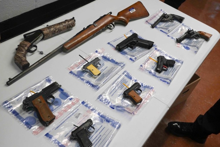 A collection of illegal guns is displayed during a gun buyback event.