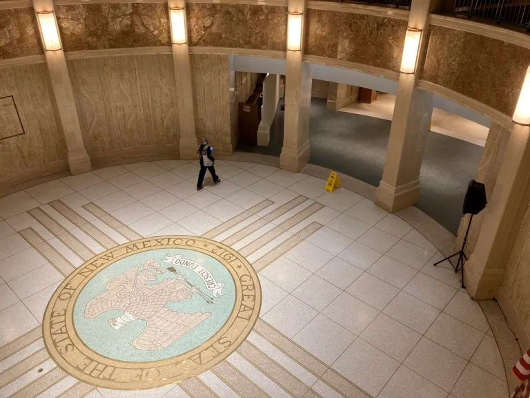 A pedestrian traverses the rotunda in the New Mexico state Capitol.