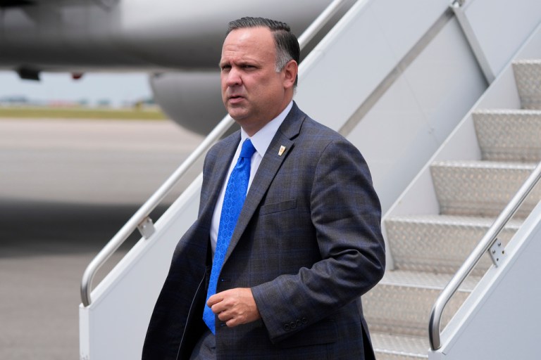 Dan Scavino walks at an airport.