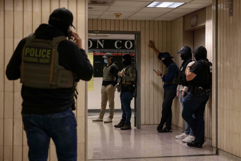 Federal agents walk around at an immigration court.