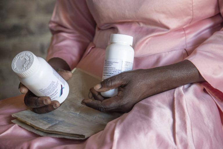 Florence Makumene holds HIV medication that she received through funding from the U.S. President's Emergency Plan for AIDS Relief, along with her hospital records book, at her home in Harare, Zimbabwe, Feb. 7, 2025.