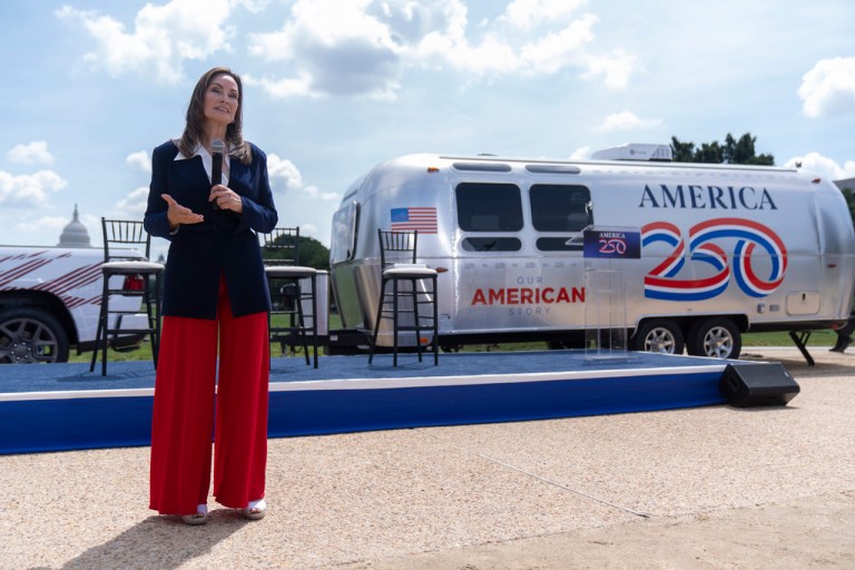 America250 chair Rosie Rios stands near a trailer that will be taken around the country to record oral and visual histories.