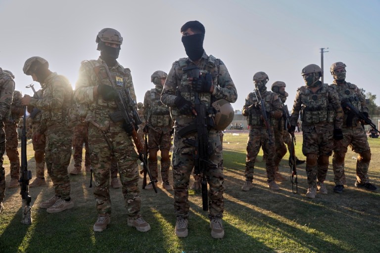 Fighters from the Syrian Democratic Forces prepare to attend a military parade.
