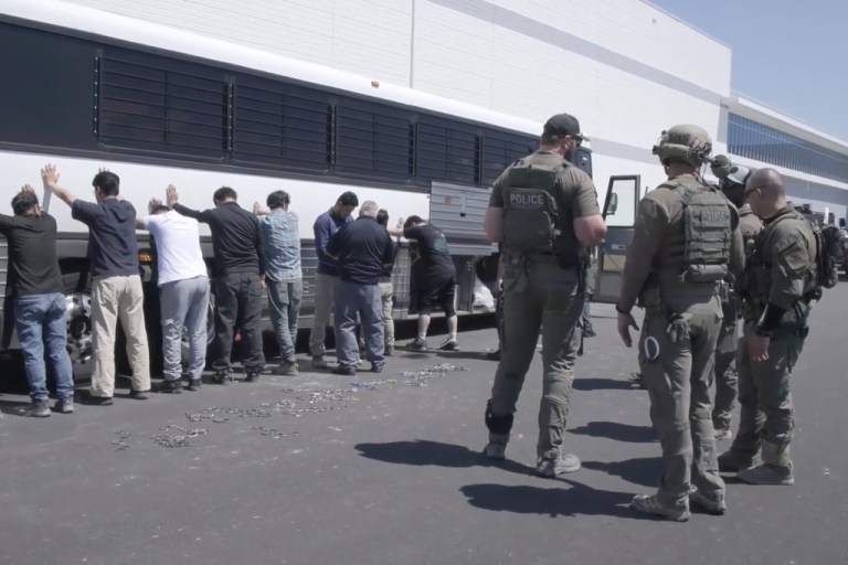 Manufacturing plant employees wait to have their legs shackled at a Hyundai Motor Group's electric vehicle plant.