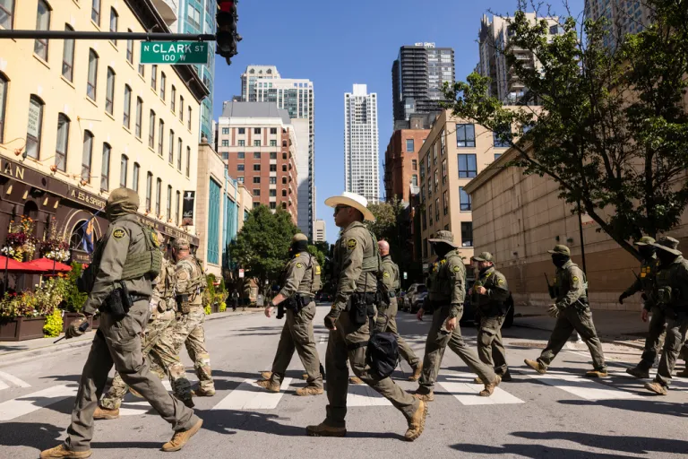 Federal agents from Immigration and Customs Enforcement and Customs and Border Protection walking across a street.
