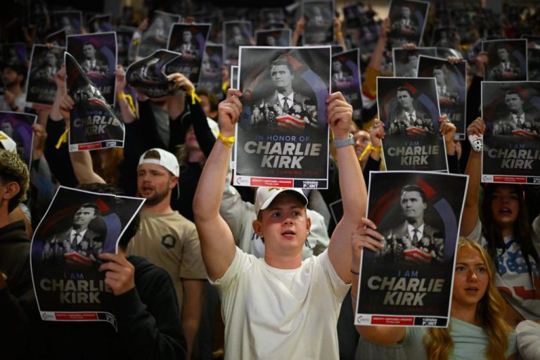 People hold posters of Charlie Kirk during a Turning Point USA rally.
