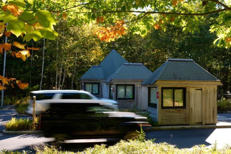 Cars drive past unstaffed entrance stations at Acadia National Park.