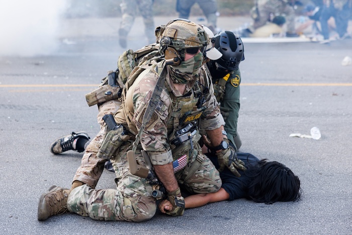 Federal officers hold down a protester in the Brighton Park neighborhood of Chicago, on Saturday, Oct. 4, 2025, after protesters learned that U.S. Border Patrol shot a woman Saturday morning on Chicago's Southwest Side. (Anthony Vazquez/Chicago Sun-Times via AP)