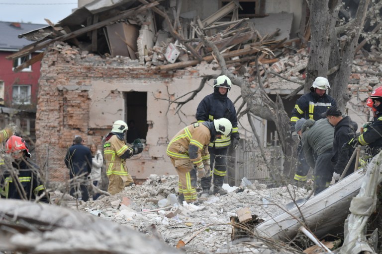Rescuers search for victims in the debris of a destroyed house following a Russian rocket strike on the outskirts of Lviv, Ukraine, Sunday, Oct. 5, 2025.