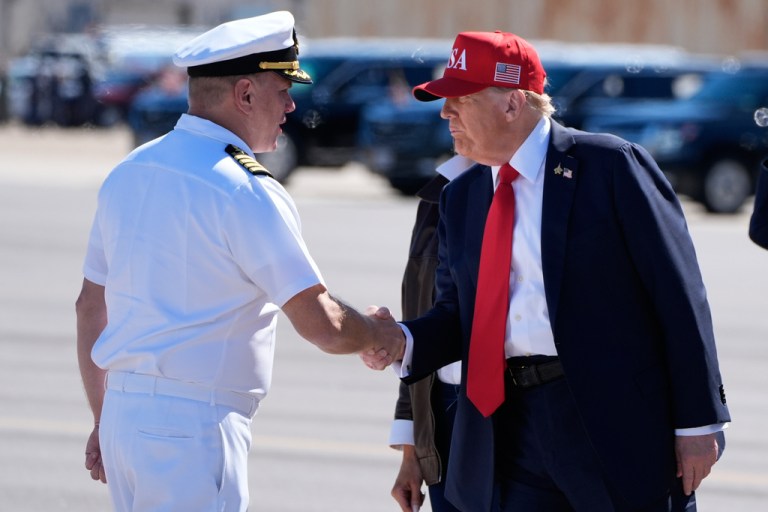 President Donald Trump greets a Navy commanding upon arriving to the Norfolk naval base.