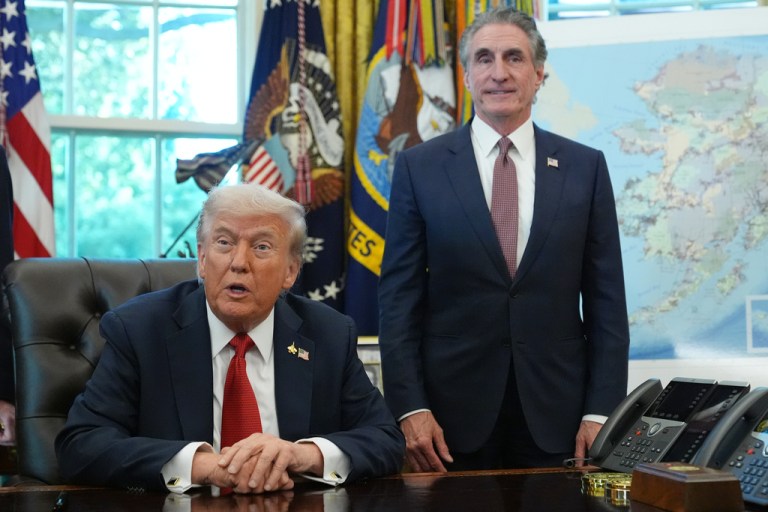 Interior Secretary Doug Burgum standing next to President Donald Trump in the Oval Office.