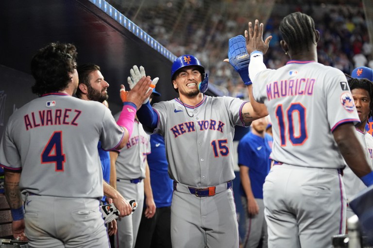 New York Mets' Tyrone Taylor (15) is congratulated after scoring on a walk by Juan Soto during the ninth inning of a baseball game against the Miami Marlins, Saturday, Sept. 27, 2025, in Miami. (AP Photo/Lynne Sladky)