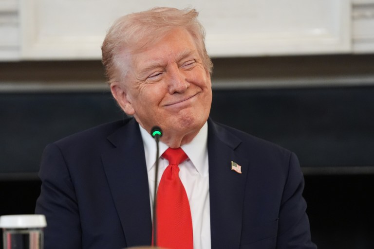 President Donald Trump smiles as he listens to Brandi Kruse speak during a roundtable meeting on antifa in the State Dining Room at the White House, Wednesday, Oct. 8, 2025, in Washington.