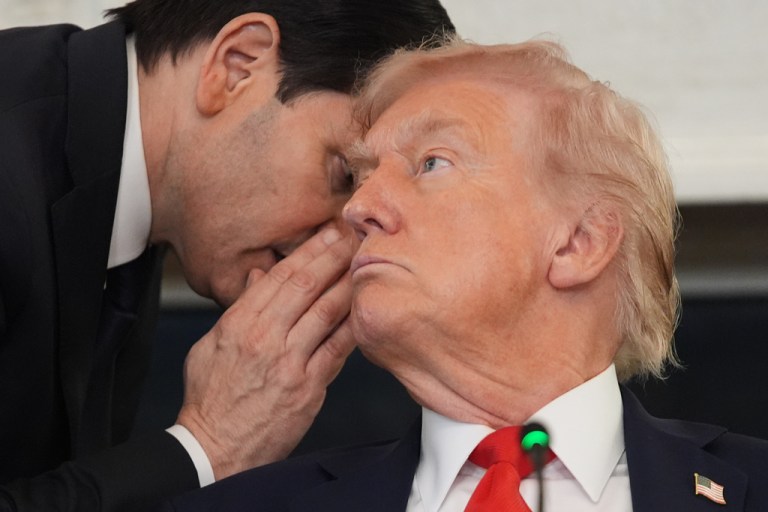 Secretary of State Marco Rubio whispers to President Donald Trump.