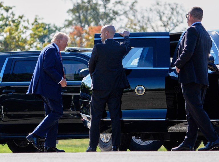 President Donald Trump walks to a car.