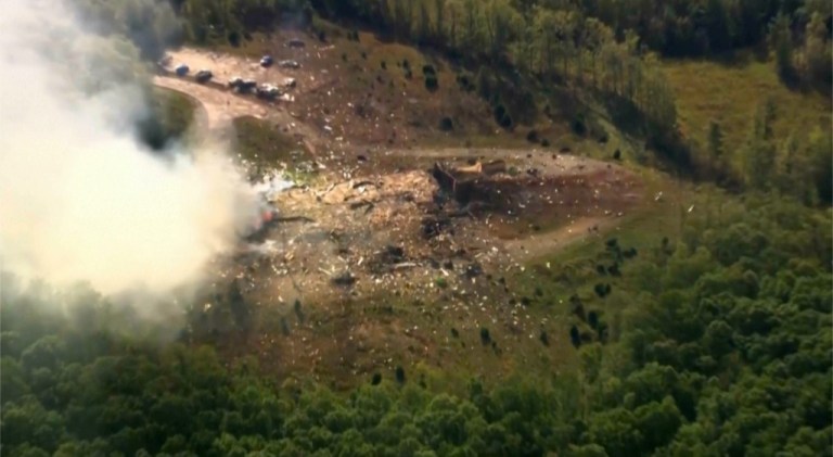 Smoke fills the air as debris covers the ground and vehicles after a powerful blast ripped through a military explosives manufacturing plant in Hickman County, Tennessee