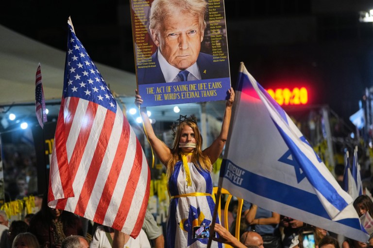 A woman holds an image of President Donald Trump at a hostage rally in Israel.