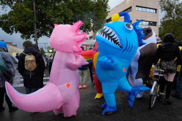 Demonstrators in inflatable costumes dance in protest outside an Immigration and Customs Enforcement facility in Portland, Oregon.